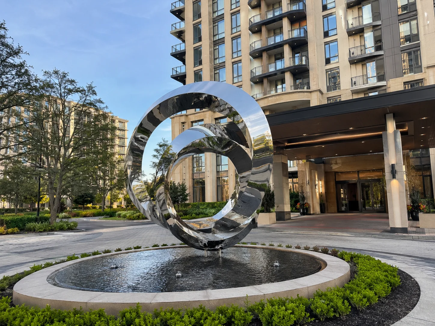 Custom mirror polished stainless steel infinity sculpture at a luxury apartment entrance in the USA