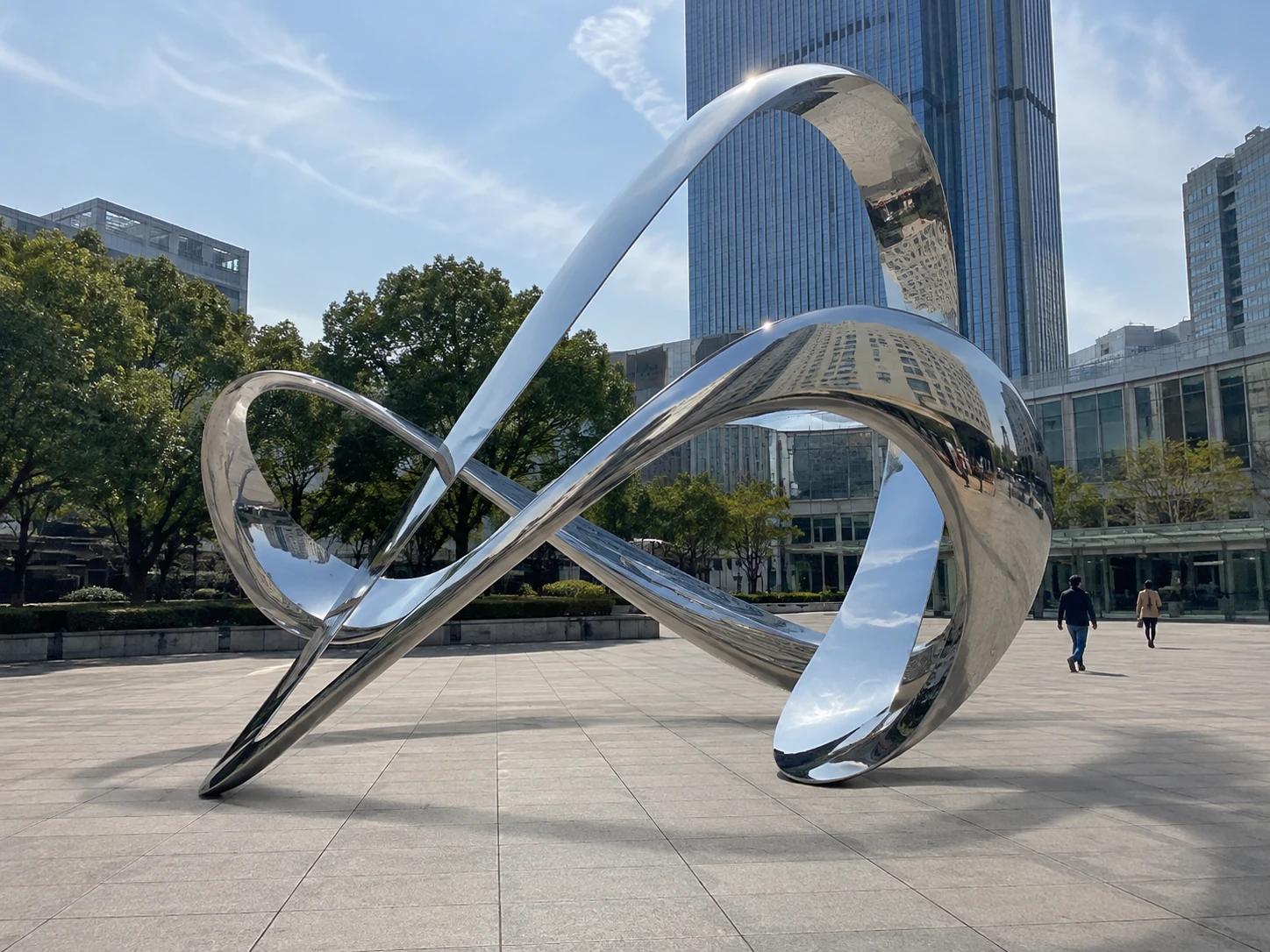 Modern mirror polished stainless steel sculpture installed in an urban public plaza for public art projects